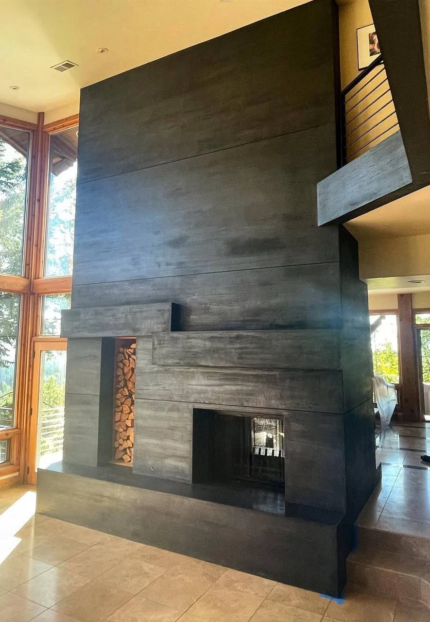 Dark grey custom interior stucco finish applied to a modern fireplace, demonstrating our color matching for indoor spaces