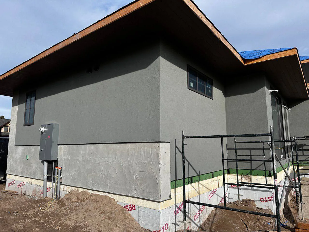 Premium dark grey EIFS stucco finish applied to a full exterior showcasing flawless coverage