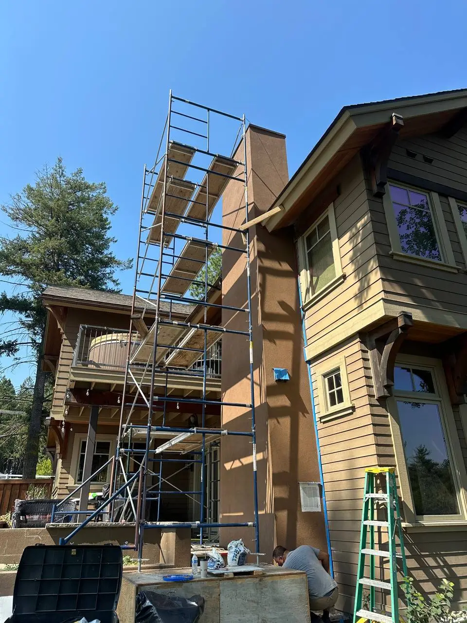 Completed high-reach residential chimney in Kalispell, MT with custom brown integrated color stucco finish